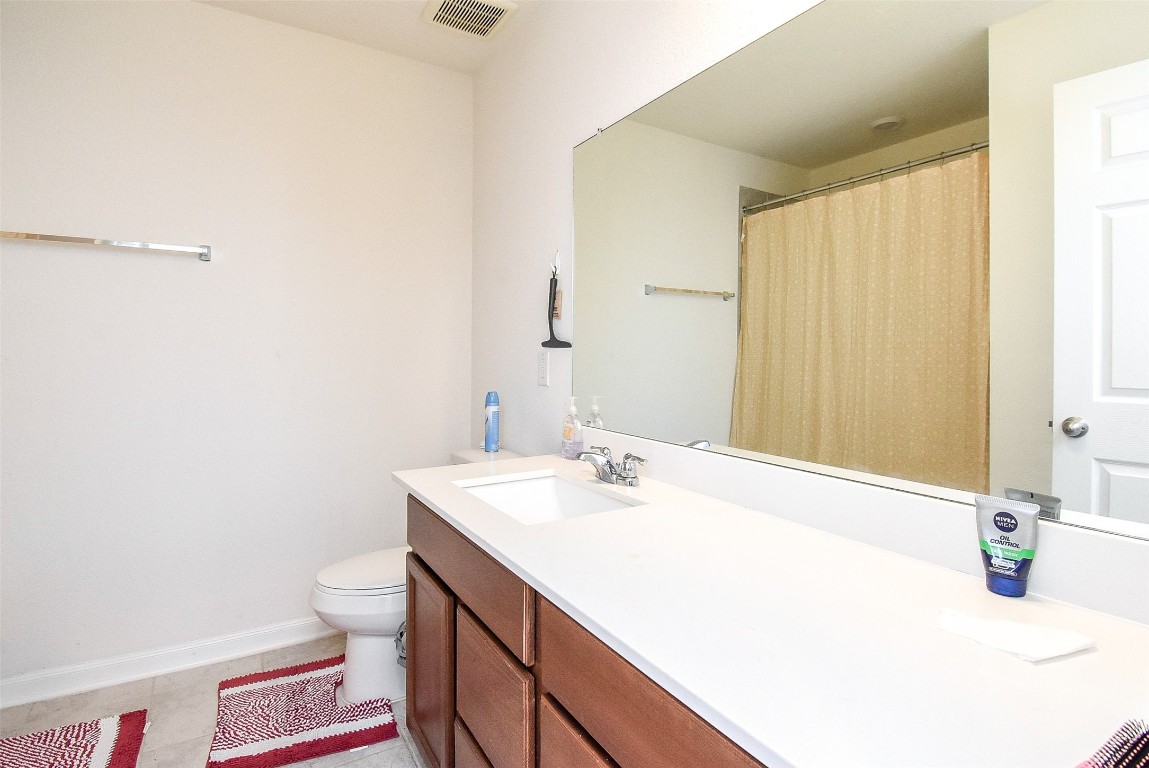 5912 Whitewing Road Rosenberg, TX 77469 - Photo 20 of 25 Spacious bathroom featuring a sleek vanity, large mirror, and a cozy tub-shower combo, perfect for relaxation and daily convenience.