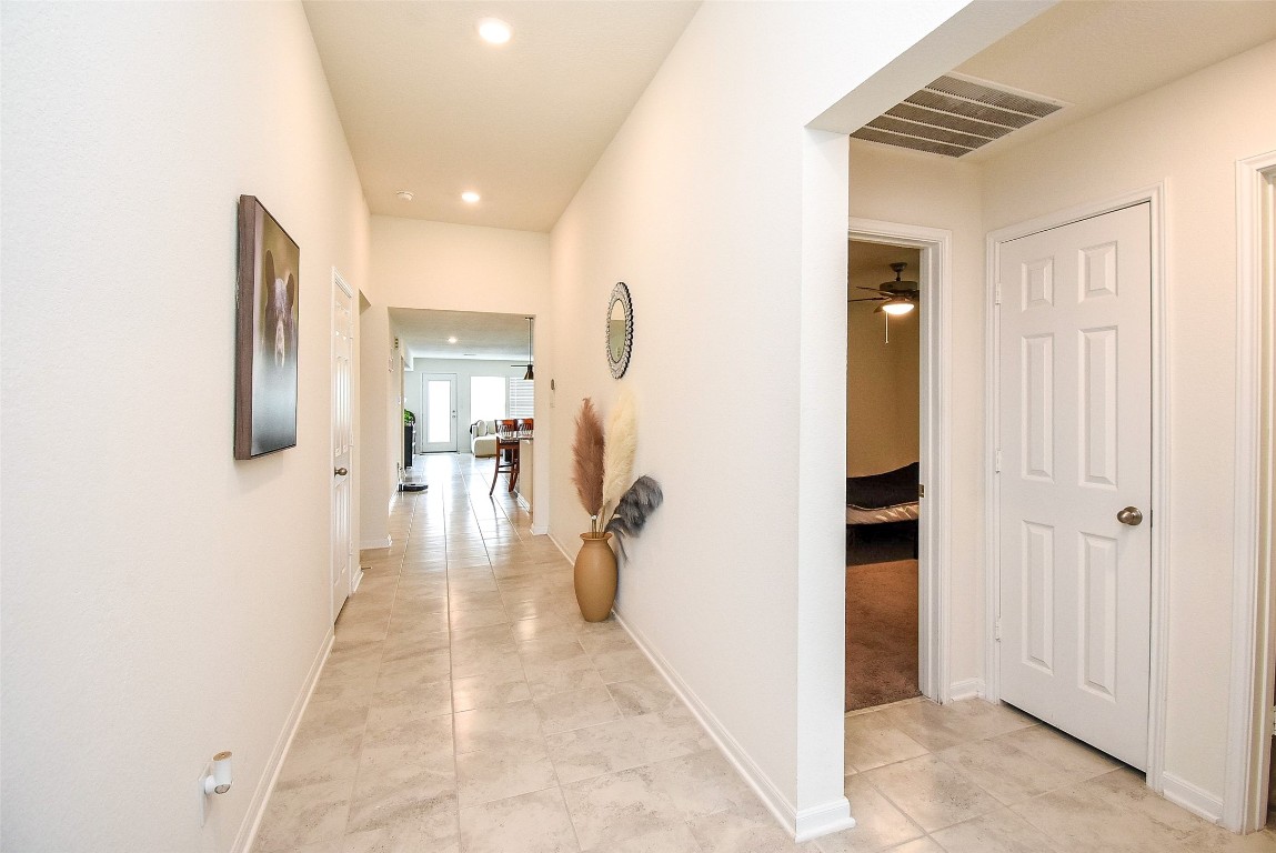 5912 Whitewing Road Rosenberg, TX 77469 - Photo 9 of 25 Spacious, inviting hallway with elegant tile flooring and ample natural light, offering a warm welcome to your home.