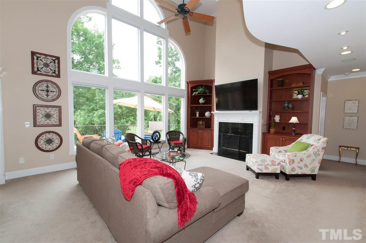 10529 Charmford Way Raleigh, NC 27615 - Photo 8 of 25 a living room with furniture a fireplace and a floor to ceiling window