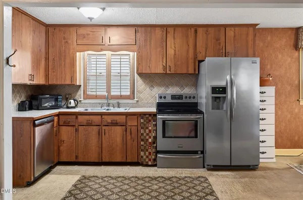 a kitchen with stainless steel appliances granite countertop a stove a sink and a refrigerator