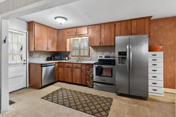 a kitchen with stainless steel appliances granite countertop a refrigerator stove and sink