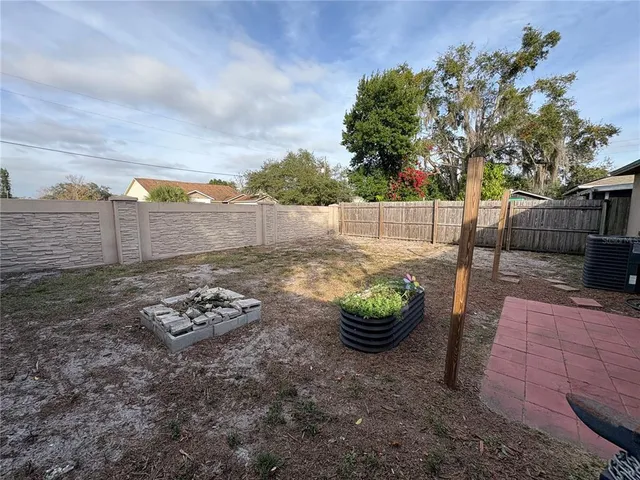 a view of a backyard with furniture and garden