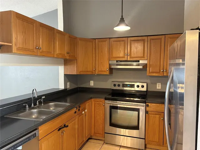 a kitchen with granite countertop a stove sink and cabinets