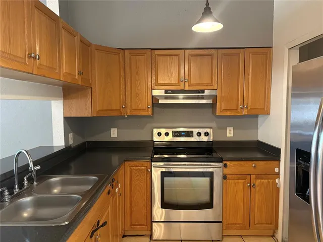 a kitchen with granite countertop a stove sink and cabinets