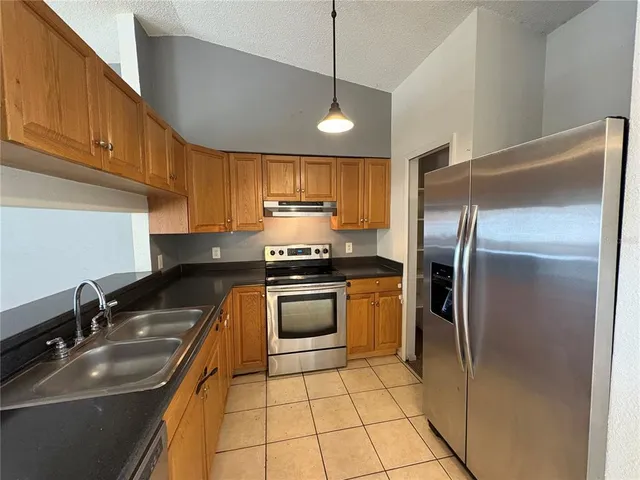 a kitchen with granite countertop a sink stainless steel appliances and cabinets