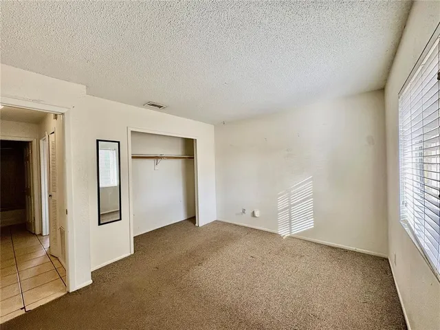 an empty room with windows and closet