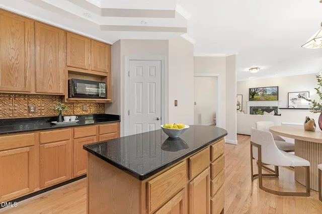 a kitchen with stainless steel appliances granite countertop a sink a stove a refrigerator cabinets and a window