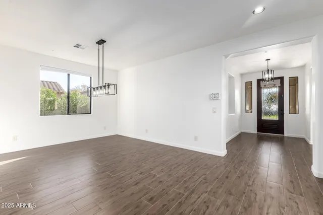 a view of a hallway with wooden floor and stairs