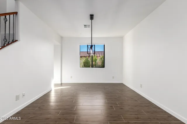 a view of a livingroom with wooden floor and a chandelier