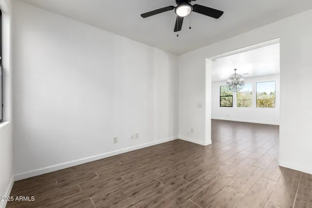 a kitchen with stainless steel appliances kitchen island granite countertop a wooden floors and white cabinets