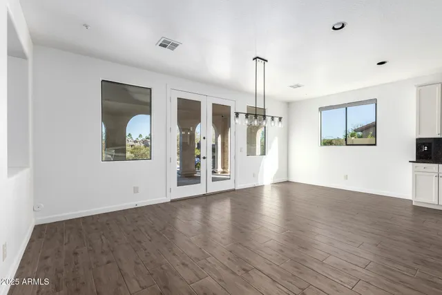 a kitchen with stainless steel appliances granite countertop a sink a stove a refrigerator and white cabinets