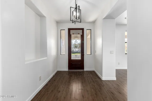 a view of a big room with wooden floor and windows