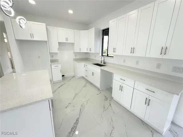 a large kitchen with stainless steel appliances granite countertop a stove a sink and a refrigerator