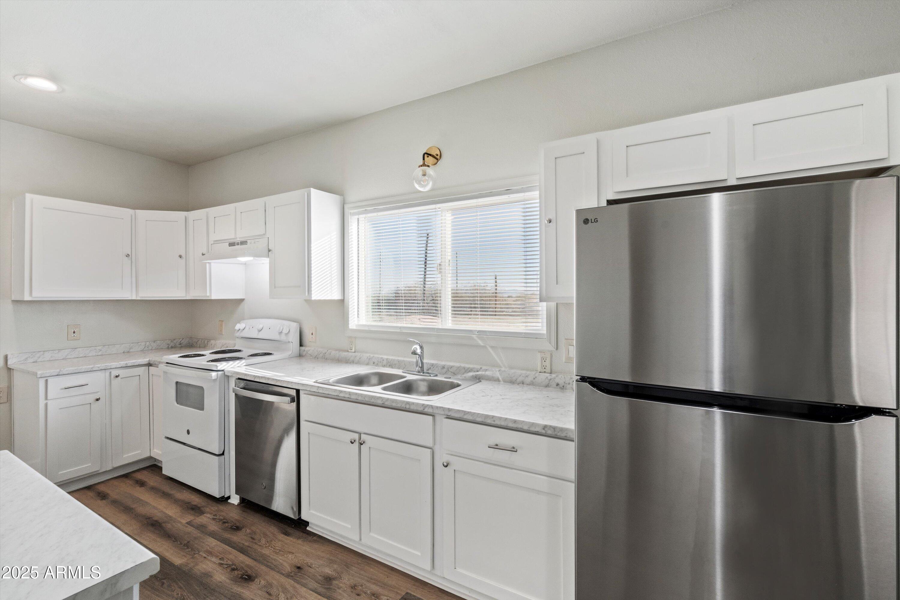 37701 West Buckeye Road Tonopah, AZ 85354 - Photo 16 of 35 a kitchen with a refrigerator a sink and a stove top oven