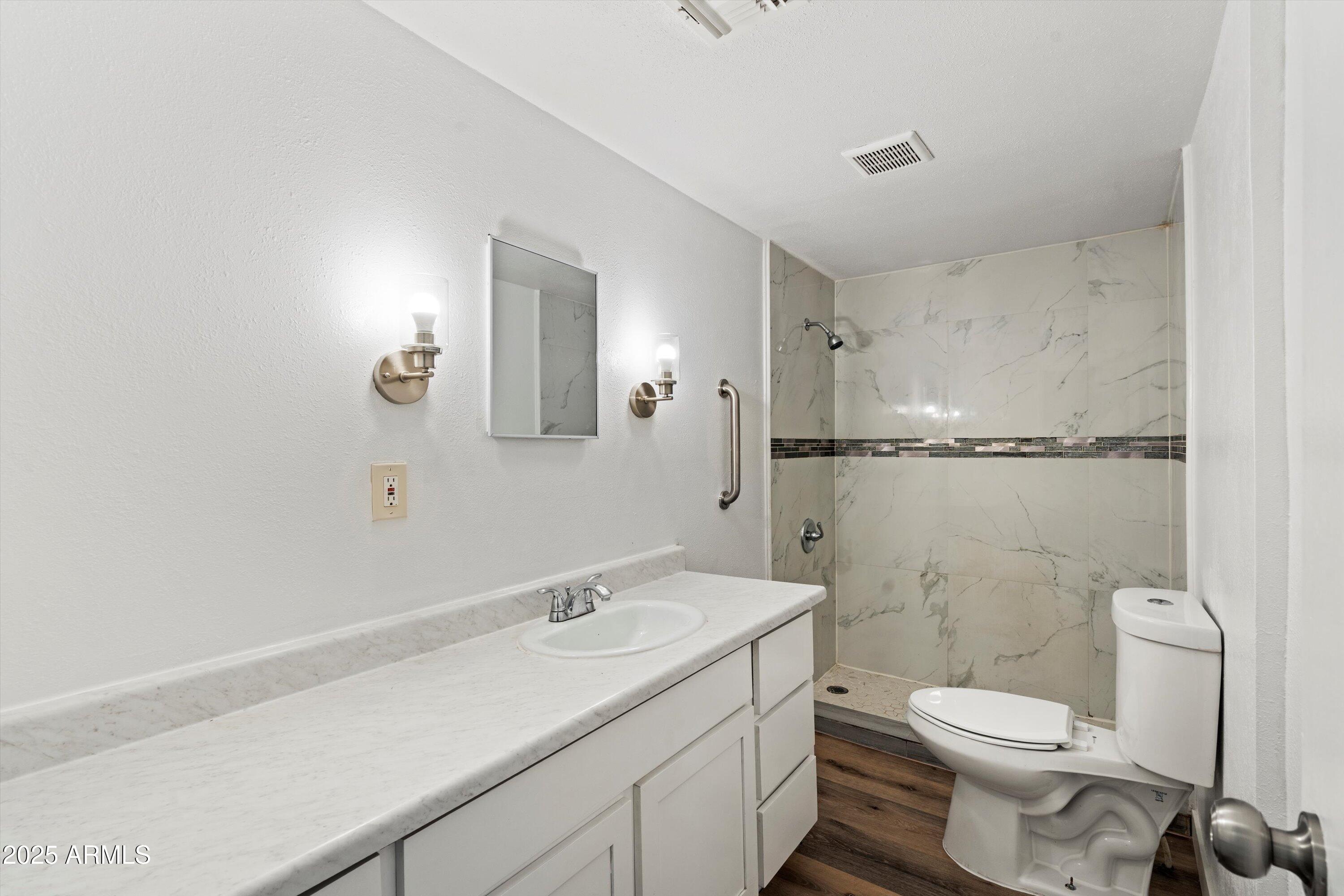 37701 West Buckeye Road Tonopah, AZ 85354 - Photo 23 of 35 a bathroom with a granite countertop toilet a sink and a mirror