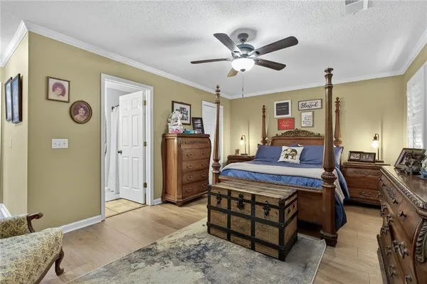 a bedroom with a bed chandelier and a window
