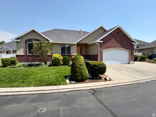 665 West State Road Lehi, UT 84043 - Photo 2 of 30 Exterior featuring a brick and stucco facade, a two-car garage, and a concrete driveway