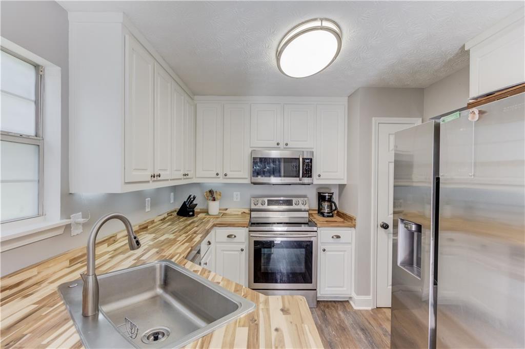 504 Oxford Ridge Winder, GA 30680 - Photo 11 of 30 a kitchen with stainless steel appliances granite countertop a sink a stove a refrigerator cabinets and a counter top space