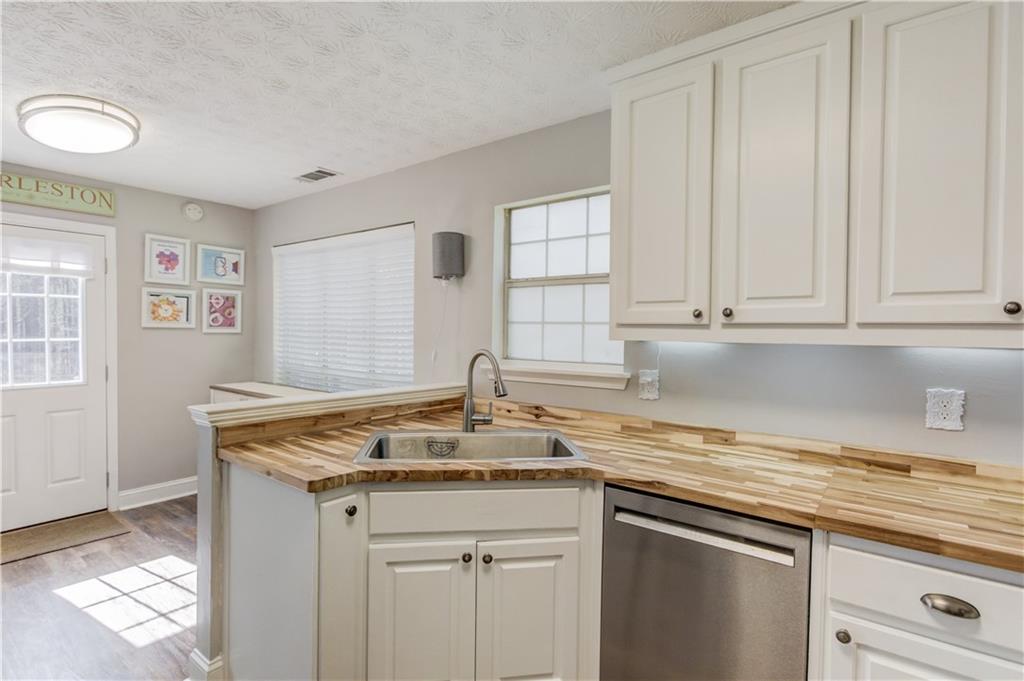 504 Oxford Ridge Winder, GA 30680 - Photo 13 of 30 a kitchen with granite countertop a sink white cabinets and a window