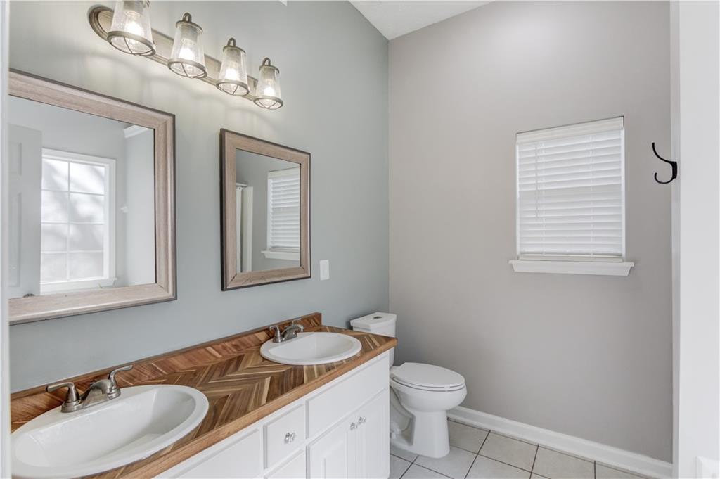 504 Oxford Ridge Winder, GA 30680 - Photo 16 of 30 a bathroom with a granite countertop sink a toilet and a mirror