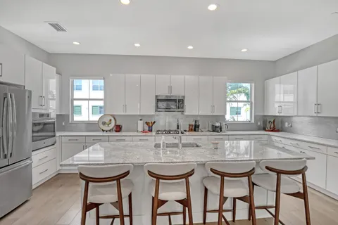 a kitchen with kitchen island granite countertop white cabinets and stainless steel appliances