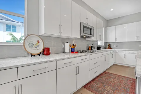 a kitchen with granite countertop white cabinets stainless steel appliances and a sink