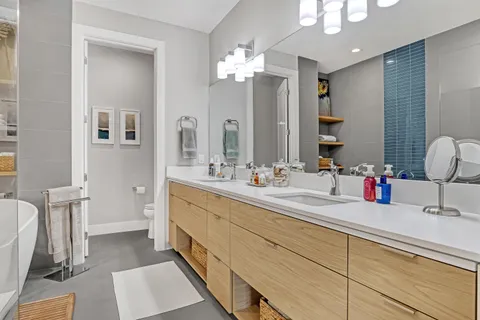 a bathroom with a double vanity sink mirror and toilet