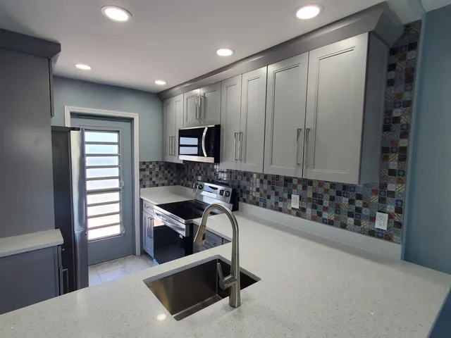 a bathroom with a granite countertop sink a toilet a mirror and shower