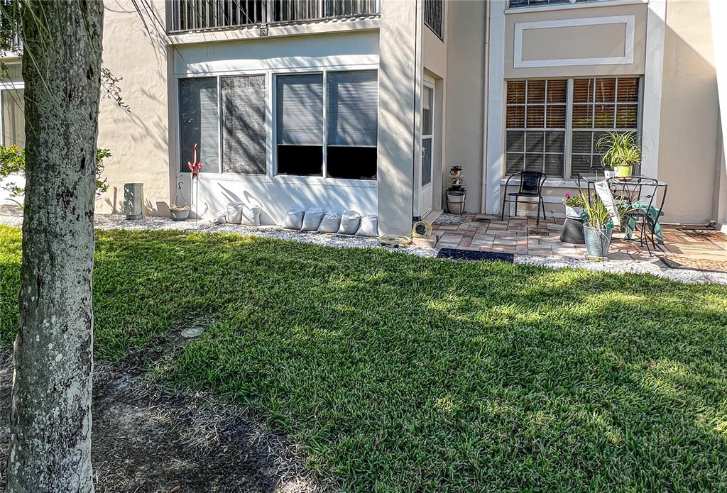 10350 Imperial Point Drive West, Unit 4 Largo, FL 33774 - Photo 24 of 68 a view of a backyard with table and chairs and potted plants