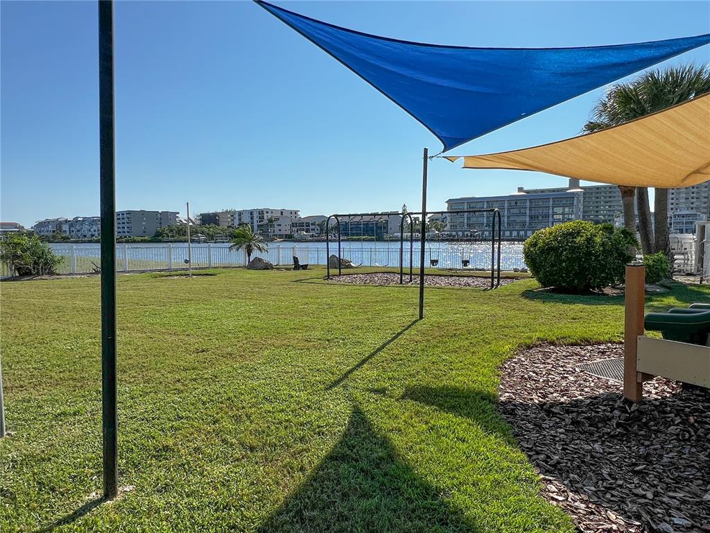 10350 Imperial Point Drive West, Unit 4 Largo, FL 33774 - Photo 33 of 68 a view of a swimming pool with a lawn chairs under an umbrella