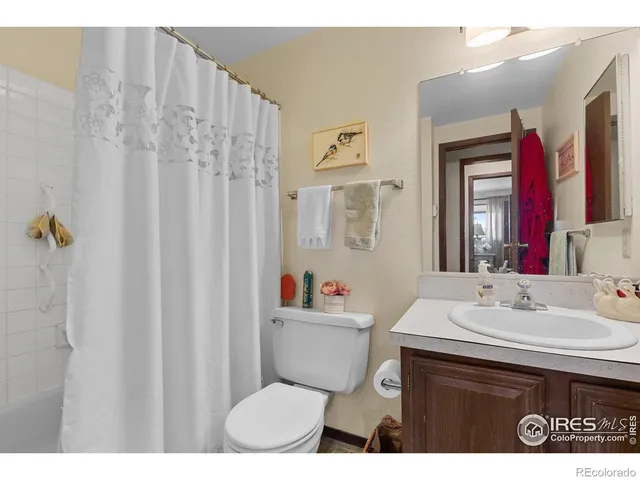 a bathroom with a sink mirror and painting on the wall