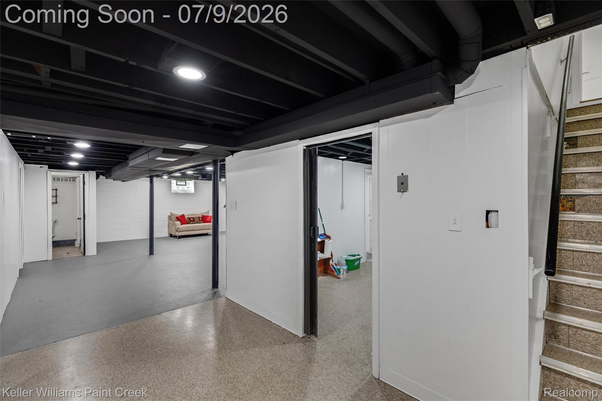 2731 Crooks Road Royal Oak, MI 48073 - Photo 19 of 34 Finished basement area featuring a painted black exposed ceiling with recessed lighting, white panel walls, and durable concrete flooring