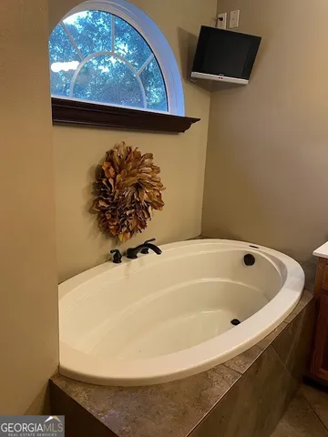 a bedroom with a bed a chandelier and a window