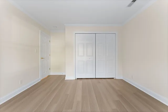 a view of an empty room with wooden floor