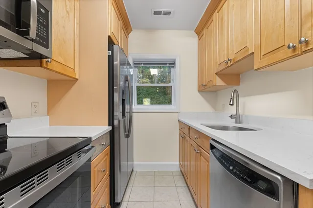 a kitchen with stainless steel appliances granite countertop a sink and a stove