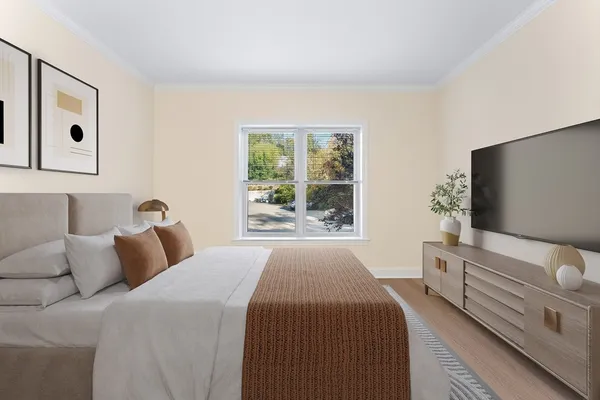 a bedroom with a bed and flat tv screen on the dresser