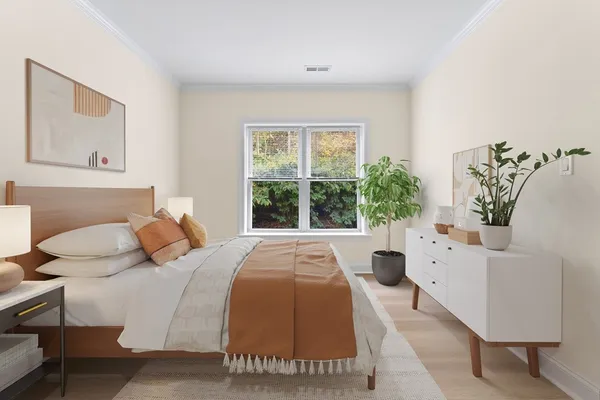 a bedroom with a bed and a large window