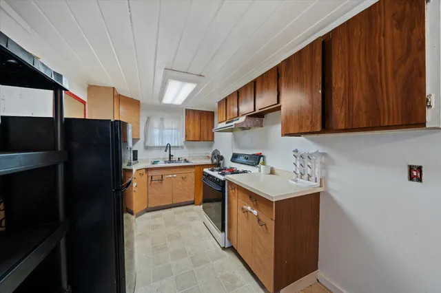 a kitchen with a sink stove and refrigerator