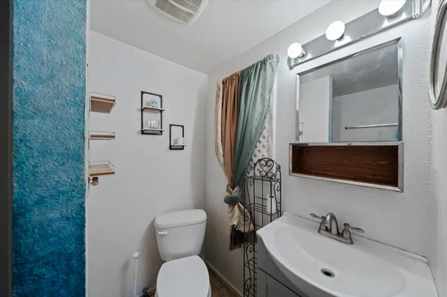 a bathroom with a toilet sink and mirror
