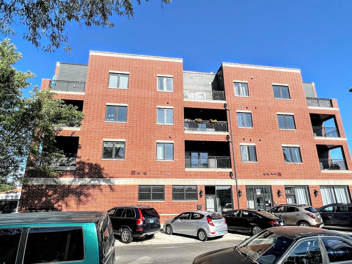 a front view of a residential apartment building with a yard