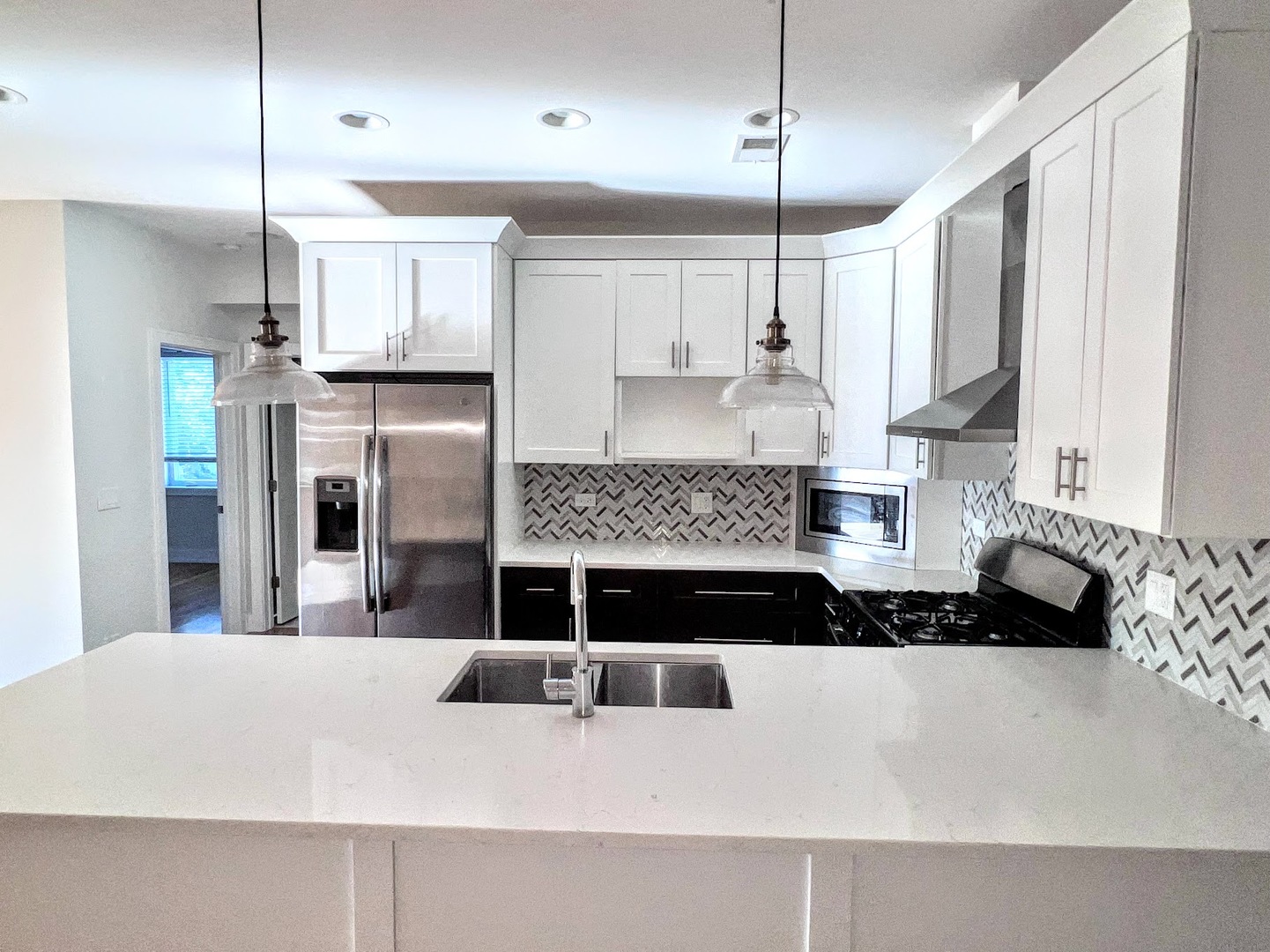 3203 North Ridgeway Avenue, Unit 3C Chicago, IL 60618 - Photo 2 of 17 a kitchen with kitchen island granite countertop a stove a refrigerator a sink and white cabinets