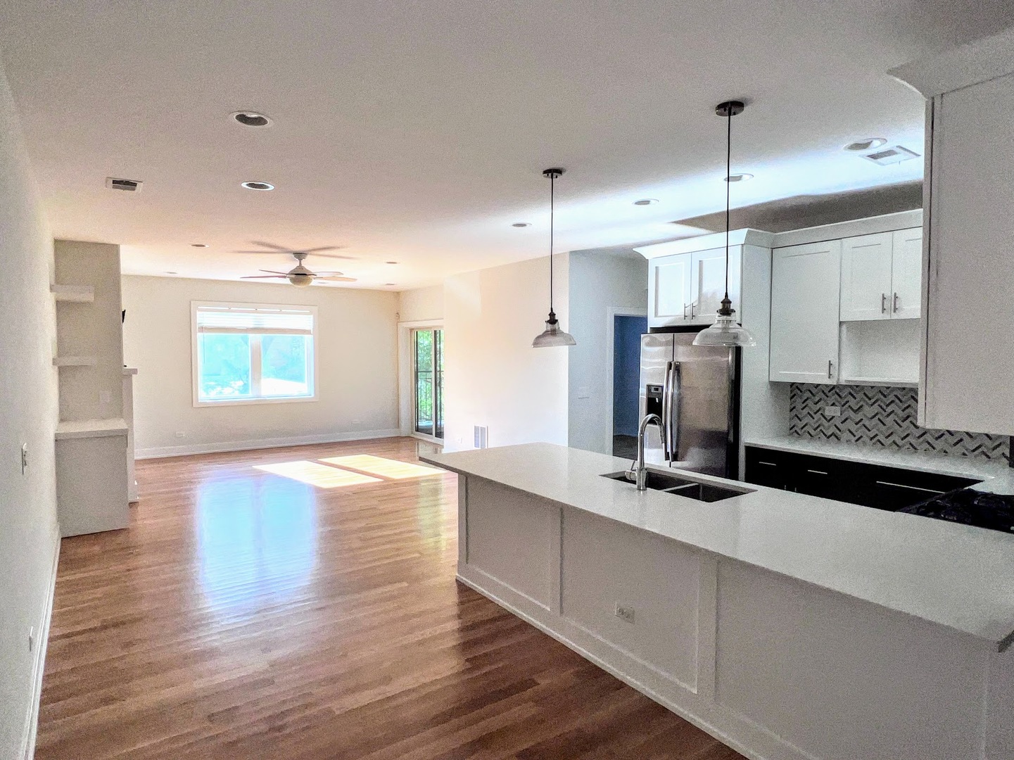 3203 North Ridgeway Avenue, Unit 3C Chicago, IL 60618 - Photo 3 of 17 a large kitchen with stainless steel appliances a large counter top a sink and a wooden floor