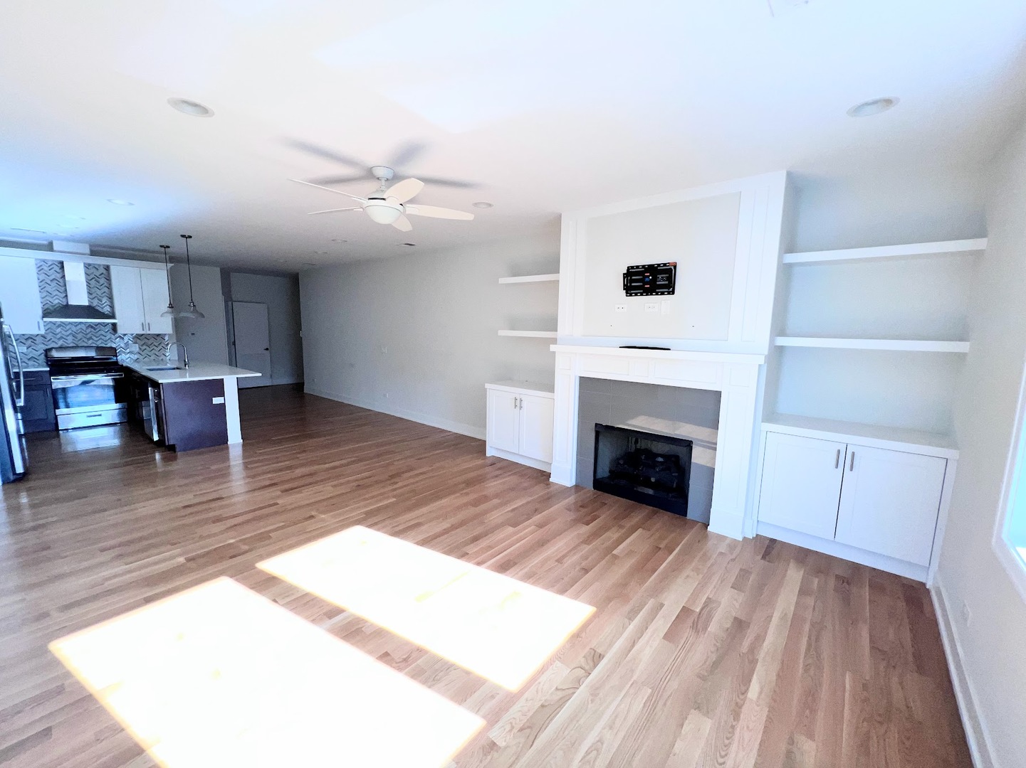 3203 North Ridgeway Avenue, Unit 3C Chicago, IL 60618 - Photo 6 of 17 a view of a livingroom with a fireplace a ceiling fan and wooden floor