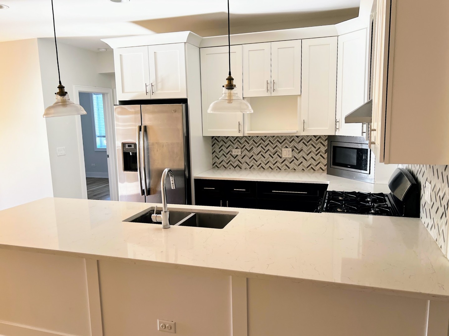 3203 North Ridgeway Avenue, Unit 3C Chicago, IL 60618 - Photo 8 of 17 a kitchen with stainless steel appliances kitchen island granite countertop a refrigerator a sink and white cabinets