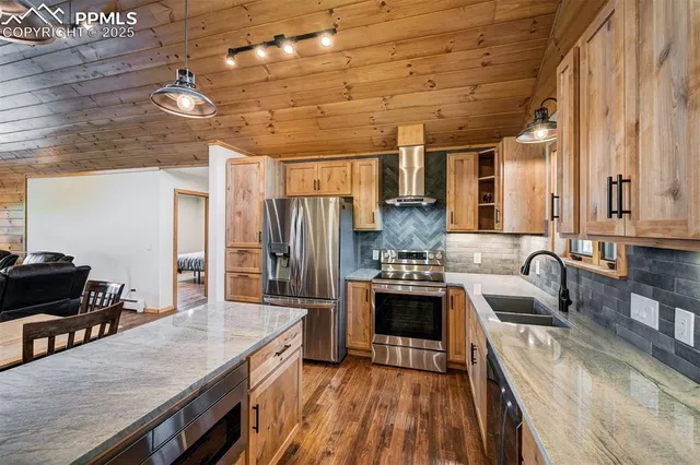 a kitchen with granite countertop a sink stove and refrigerator