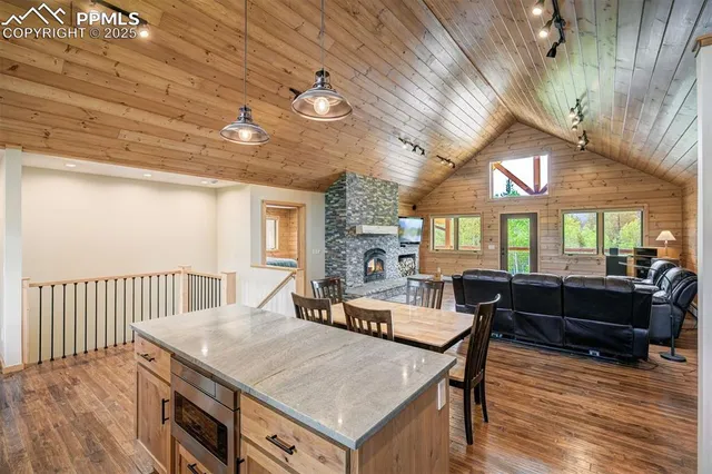 a living room with furniture a large window and wooden floor