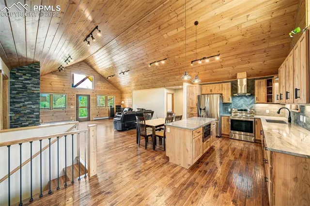 a living room with lots of white furniture and wooden floors
