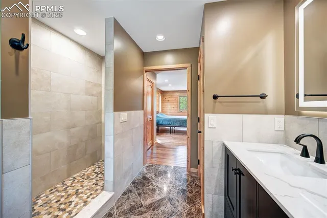 a bathroom with a granite countertop sink a mirror and a shower