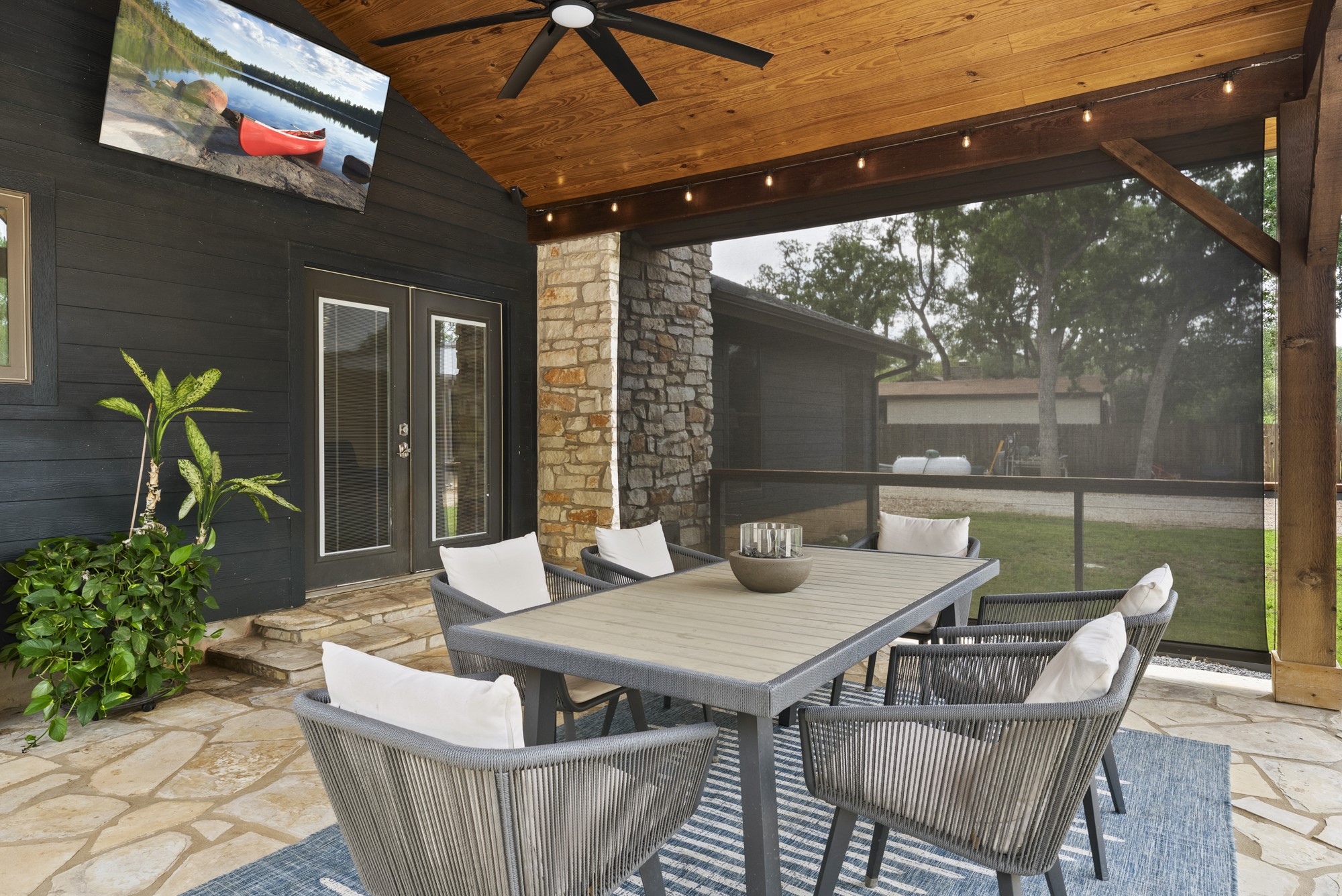 2802 Robin Road Manchaca, TX 78652 - Photo 19 of 40 Covered outdoor living space featuring a natural wood-paneled ceiling, ceiling fan, string lighting, and stone column