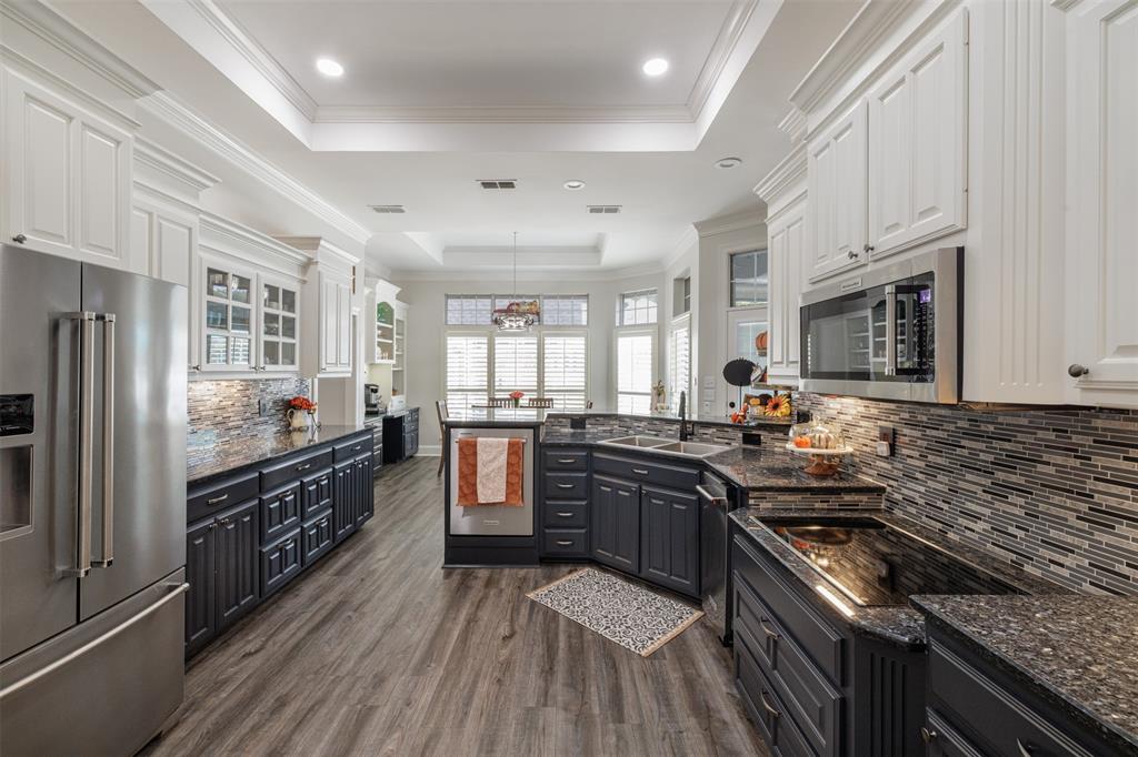 106 Graham Lane Bullard, TX 75757 - Photo 13 of 39 a kitchen with stainless steel appliances granite countertop a stove top oven a sink dishwasher a refrigerator and white cabinets with wooden floor